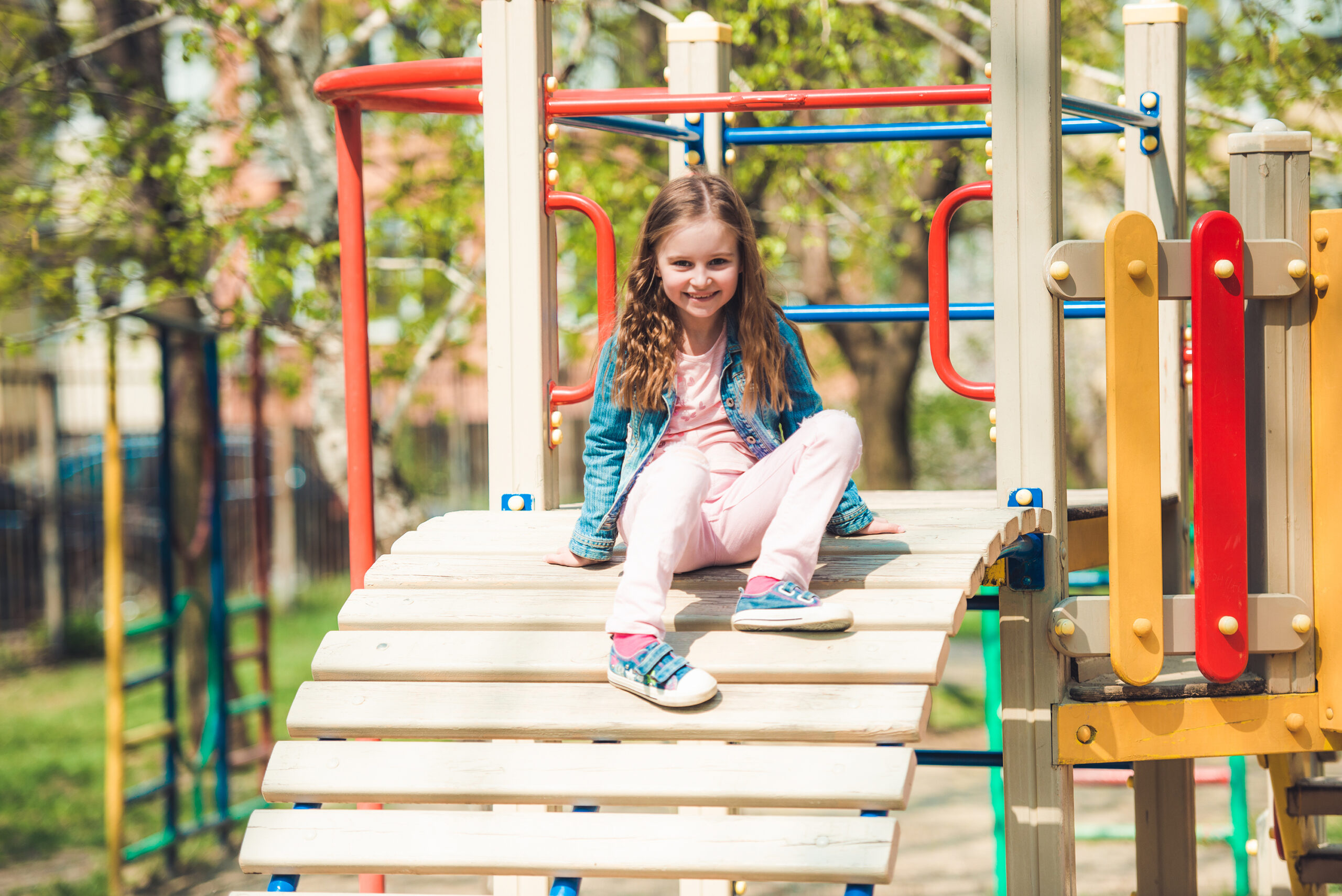 little girl playing on a playground ladder